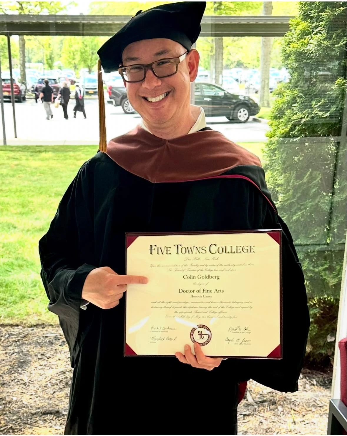Colin Goldberg holding his honorary Doctor of Fine Arts diploma from Five Towns College